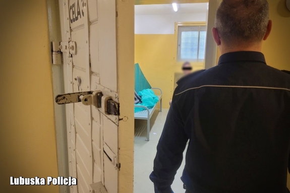 policjant obserwuje mężczyznę osadzonego w celi