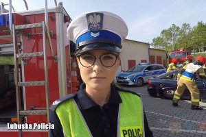 policjantka podczas kręcenia klipu na tle samochodu strażackiego.