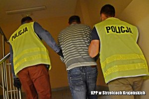 Policjanci prowadzą zatrzymanego