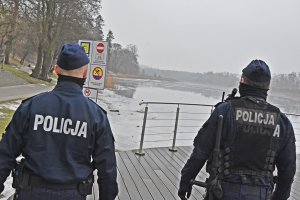 Policjanci patrolują brzeg zamarziętego jeziora