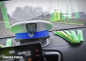 Widok policyjnej czapki i odbalsków w radiowozie