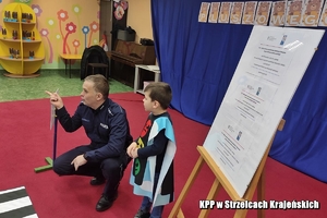 Policjant rozmawia z dziećmi o bezpieczeństwie.