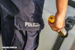 Policjant trzyma w ręce urządzenie do badania stanu trzeźwości