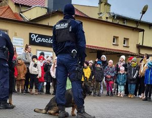 Policjanci prezentują dzieciom policyjnego psa.