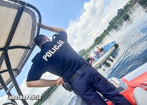 Policjant i ratownik na łodzi motorowej