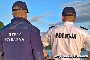 Widok policjanta i funcjonariusza straży rybackiej na łodzi