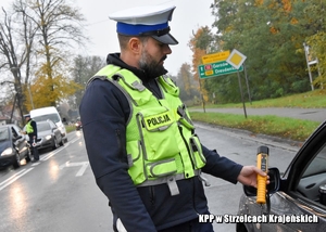 Policjant w trakcie kontroli drogowej sprawdza stan trzeźwości